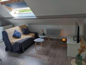 a living room with a couch and a window at Le petit château in Pierrefonds