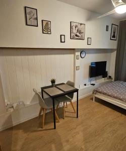 Zimmer mit einem Tisch, Stühlen und einem Bett in der Unterkunft Smulik Flat 21 in Warschau