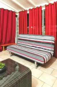 バステールにあるAppartement de 2 chambres avec jardin clos et wifi a Basse Terreの赤いカーテン付きの部屋の大きなベンチ