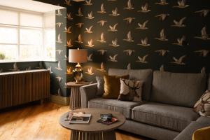sala de estar con sofá y papel pintado de pájaro en Galgorm en Ballymena