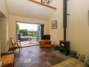 - un salon avec un poêle à bois dans l'établissement Lovesome Cottage, à Danby Wiske
