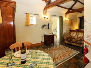un salon avec une table avec une bouteille de vin dans l'établissement Lovesome Cottage, à Danby Wiske