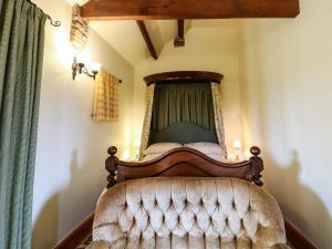 une chambre avec un lit à baldaquin dans l'établissement Lovesome Cottage, à Danby Wiske