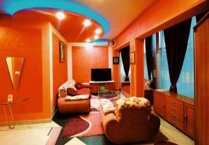 a living room with two chairs and a television at Apartmani Lazić in Gracanica