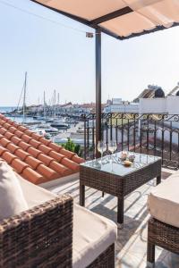 eine Terrasse mit einem Tisch und Stühlen sowie einem Yachthafen in der Unterkunft Manus Dei Exclusive Suites in Pythagoreio