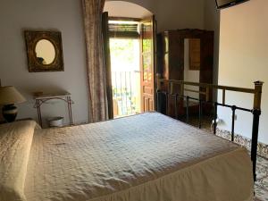 1 dormitorio con 1 cama en una habitación con ventana en Casa Churruca, en Jaraíz de la Vera