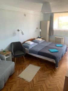 a hotel room with two beds and a chair at Szépasszonyvölgyi Apartman in Eger