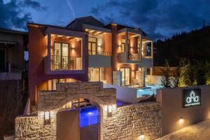 a building with a stone wall in front of it at Aria Luxury Residence in Syvota