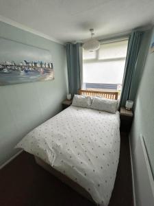a small bedroom with a bed with a window at Seaside Escape Chalet in Bridlington in Bridlington +6 photos
