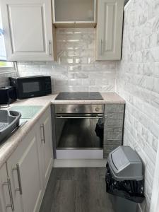 a kitchen with a stove and a sink at Cozy Seaside Chalet in Bridlington in Bridlington