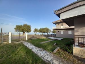 a yard next to a house with a fence at Basilio's Studios in Leptokaria