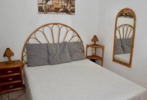 a bedroom with a white bed and two mirrors at casa Maruzza in Casteldaccia