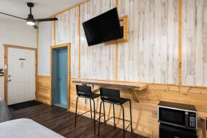 Pokój z dwoma stołkami barowymi i telewizorem na ścianie w obiekcie Moose Inn w mieście Spirit Lake