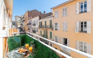 un balcón con una mesa con comida y bebidas. en Magnifique studio centre Cannes Vieux port-Croisette-Plages, en Cannes