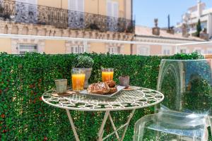 una mesa con una bandeja de comida y dos vasos de zumo de naranja en Magnifique studio centre Cannes Vieux port-Croisette-Plages, en Cannes