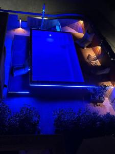 Boutique Hotel Sirmione في سيرمِيوني: شاشة كبيرة على طاولة مع أضواء زرقاء
