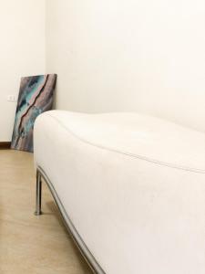 um sofá branco num quarto com uma pintura em Energia Perfeita Casa Solar Milagres em Americana
