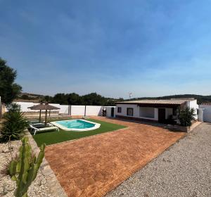 einen Hinterhof mit einem Pool und einem Haus in der Unterkunft BAMBÚ · Casa rural en Vejer con piscina privada in Vejer de la Frontera