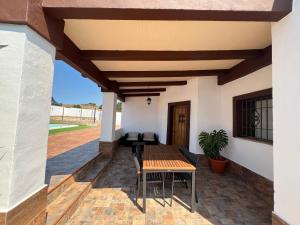 eine Terrasse eines Hauses mit einem Tisch und Stühlen in der Unterkunft BAMBÚ · Casa rural en Vejer con piscina privada in Vejer de la Frontera
