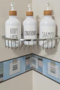 a shelf with four bottles on it in a bathroom at Casa Maja in Costa de Antigua