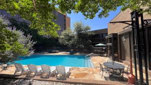 una piscina con sedie e un tavolo accanto a un edificio di MCM Elegante Hotel a Odessa