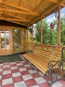un banco de madera sentado bajo un techo de madera en Amirhan Guest house en Bokonbayevo