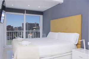 een slaapkamer met een wit bed en een groot raam bij Texas in Alicante