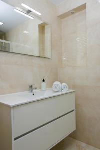 y baño con lavabo blanco y espejo. en Texas en Alicante