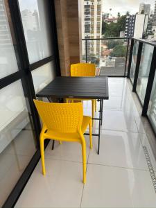 d'une table et de chaises sur un balcon avec vue. dans l'établissement House Barra 603 · Novíssimo apt Vista Mar na Barra, à Salvador