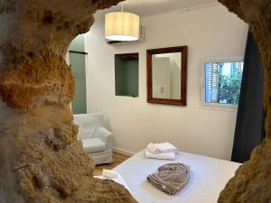 a room with a bed and a chair and a mirror at Baglio San Giovanni in Palermo