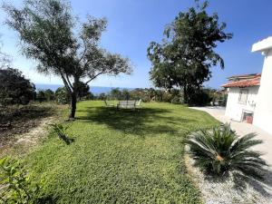 a park with a bench and a tree in the grass at Villetta Suite indipendente in Santa Maria +4 photos