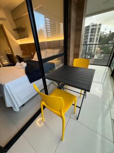 Cette chambre comprend un lit, une table et des chaises. dans l'établissement House Barra 603 · Novíssimo apt Vista Mar na Barra, à Salvador