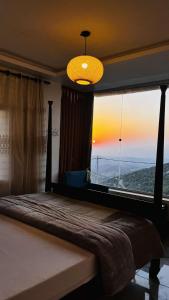 1 dormitorio con 1 cama y ventana grande en Mustafa Farm, en Ajloun