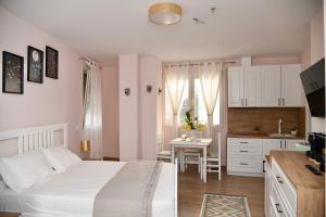 a bedroom with a bed and a kitchen with a table at Villa Rosa in Durrës