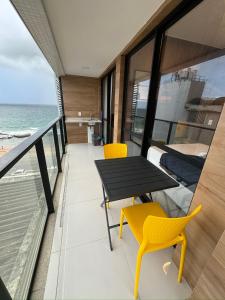 d'un balcon avec une table et des chaises donnant sur l'océan. dans l'établissement House Barra 603 · Novíssimo apt Vista Mar na Barra, à Salvador
