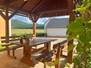 a wooden picnic table on a patio with a barn at Barbara in Otočac