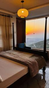 uma cama grande num quarto com uma janela grande em Mustafa Farm em Ajlun