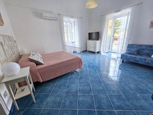 a bedroom with a bed and a blue tile floor at Maridea - Marlin in Ponza