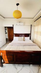 Cama grande de madera en un dormitorio con lámpara de araña en Mustafa Farm en Ajloun