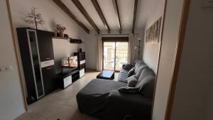 a living room with a couch and a television at CA LIDIA - Apartamentos Turisticos EL BALCONET in Benimantell