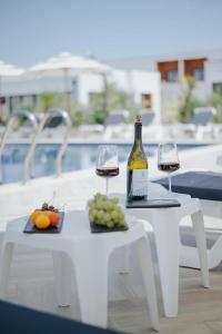 a table with two glasses of wine and a plate of fruit at Imperial Family Resort in Ulcinj