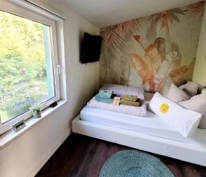 a small bed in a room with a window at Ferienhaus Grüner Bungalow Kontaktloser CheckIn in Stendell