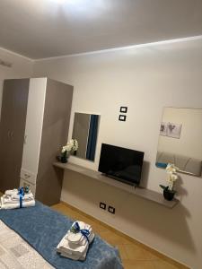Pokój z łóżkiem i telewizorem z płaskim ekranem w obiekcie appartamento residence via giardini Acquamarina w mieście San Vito lo Capo