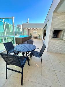 a patio with a table and chairs on a balcony at Linda Cobertura duplex- 306 Bayside in Bombinhas
