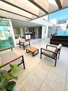 a patio with chairs and tables on a building at Linda Cobertura duplex- 306 Bayside in Bombinhas