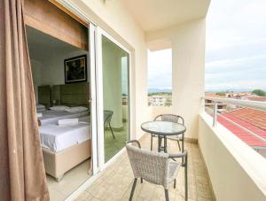 1 dormitorio con balcón con 1 cama y 1 mesa en Imperial Hotel, en Ulcinj