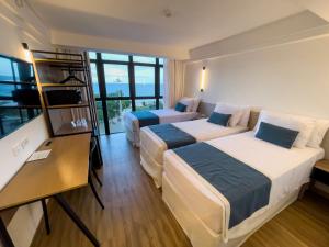 Cette chambre comprend deux lits et une télévision. dans l'établissement Marante Plaza Hotel, à Récife
