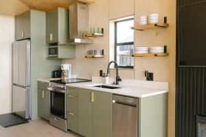 a kitchen with green and white cabinets and a sink at Yellowstone Peaks Hotel in Island Park +39 photos