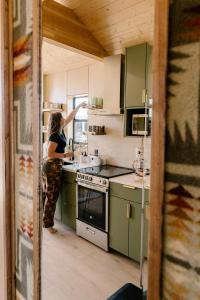 una mujer parada en una cocina preparando comida en Yellowstone Peaks Hotel, en Island Park
