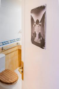 a bathroom with a toilet with a picture on the door at Casa Emma in Corralejo +24 photos